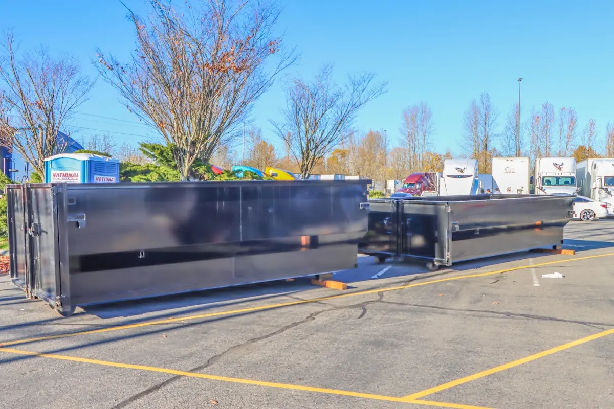 Professional dumpster rental service with roll-off container on residential driveway in Howell